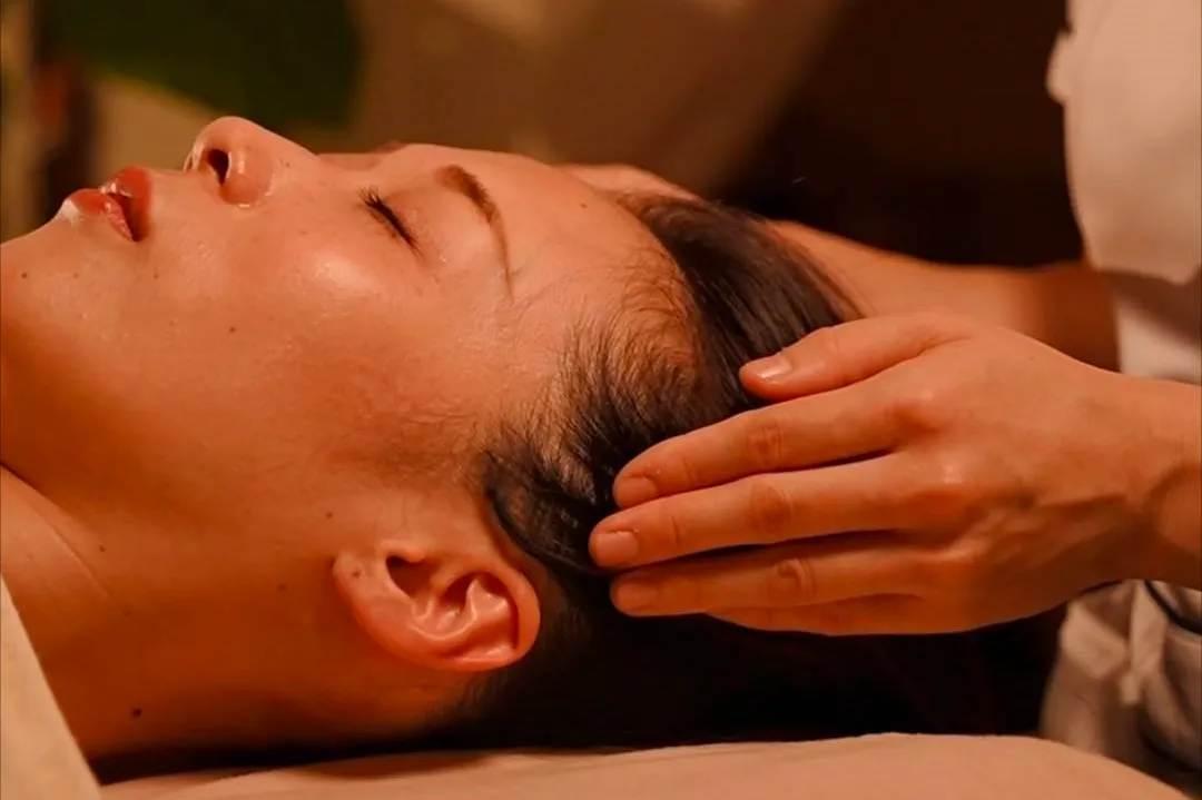 頭部に優しく触れる施術